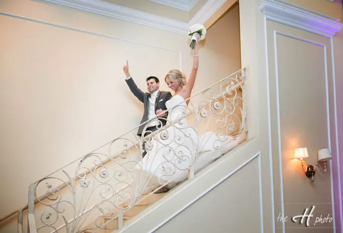 bride and groom coming down the impressive staircase