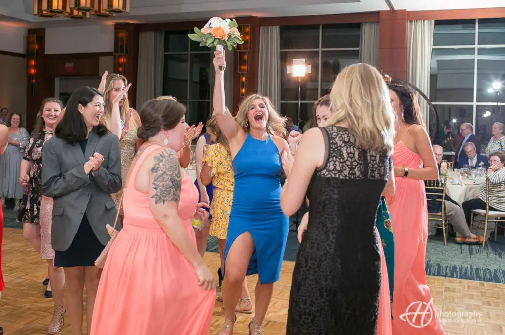 Bride's bouquet was caught by the sexy single lady in blue dress. catching-the-bouquet