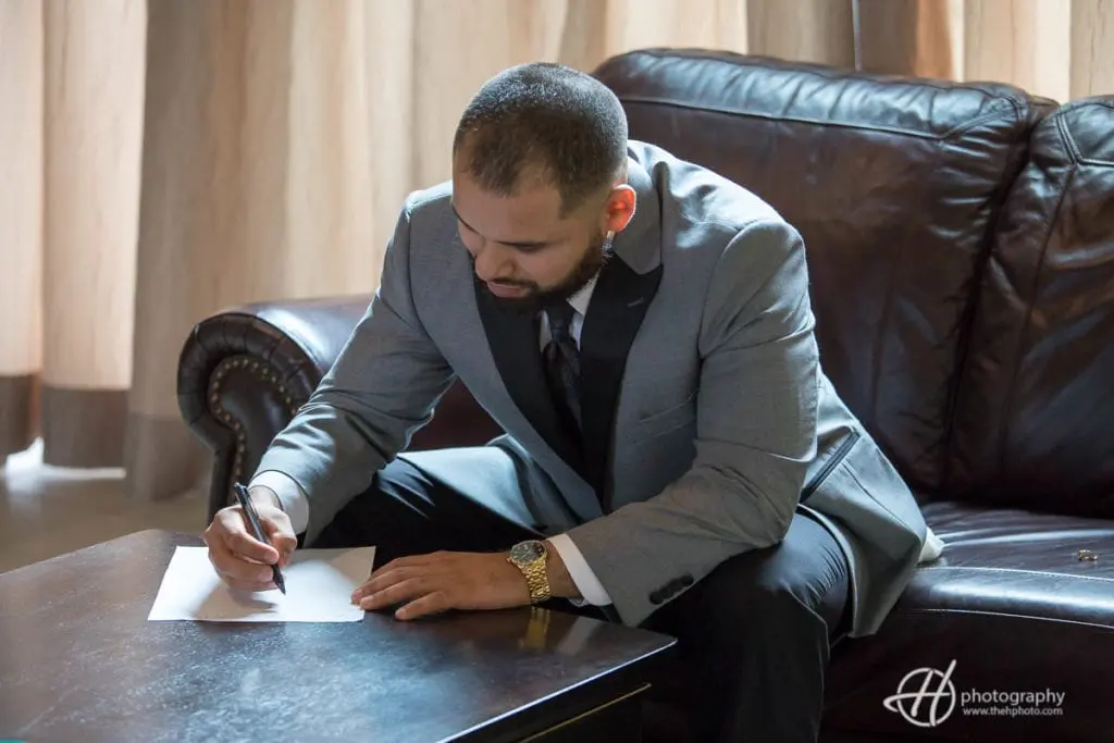 Jesus writting a letter for Tanya to ready before ceremony. groom-writting-letter