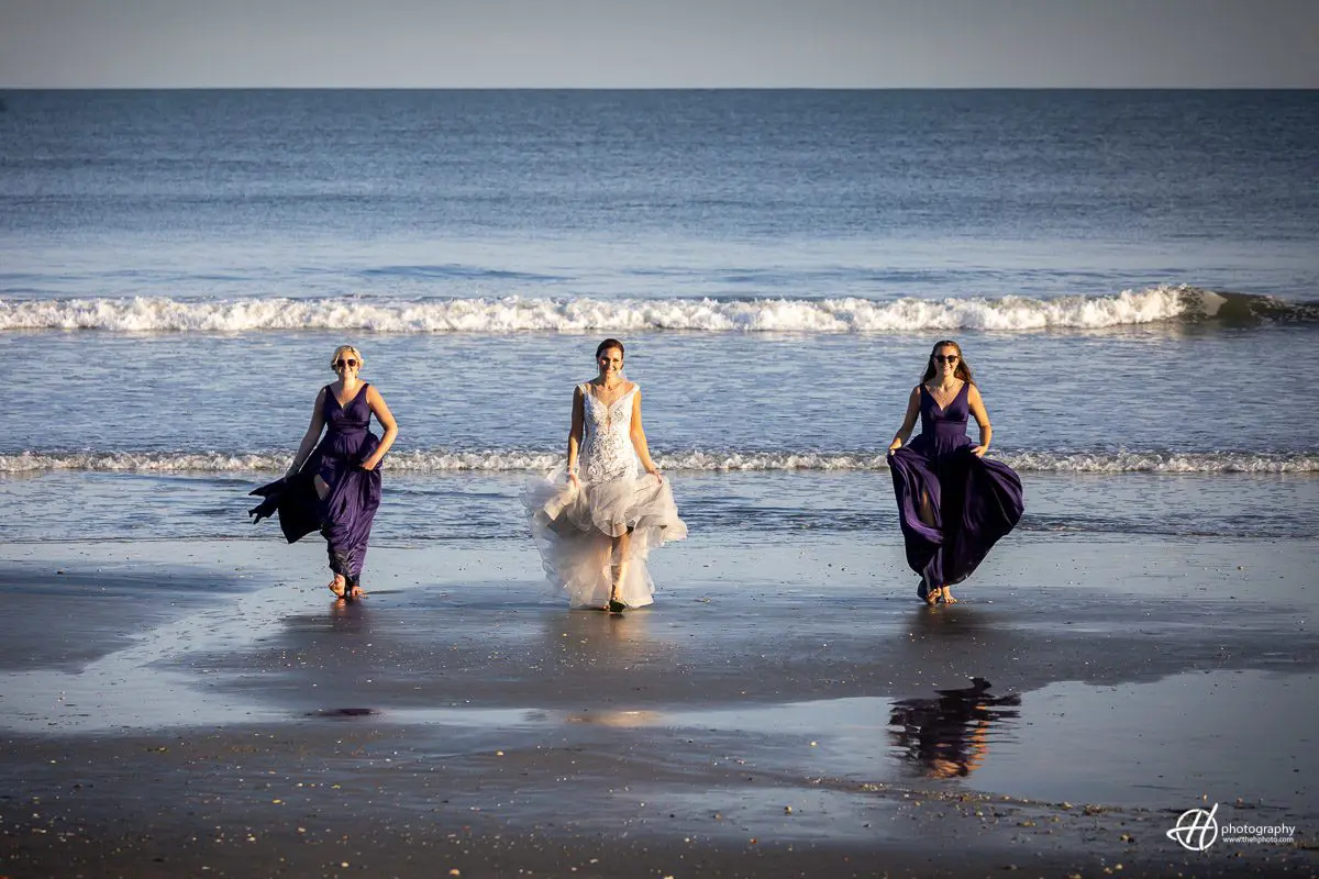bride and bridemaids walking by the beach 