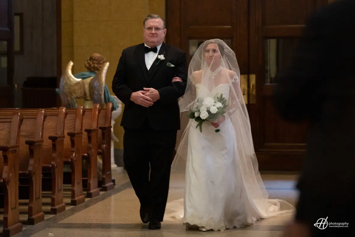 Mary walking down the aisle with her father. walking down the aisle