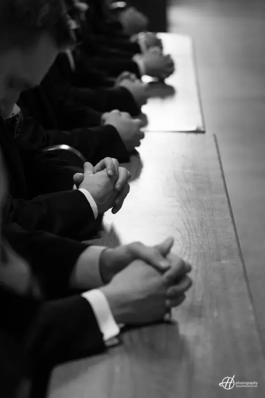 Groomsmen praying. bw candid shot