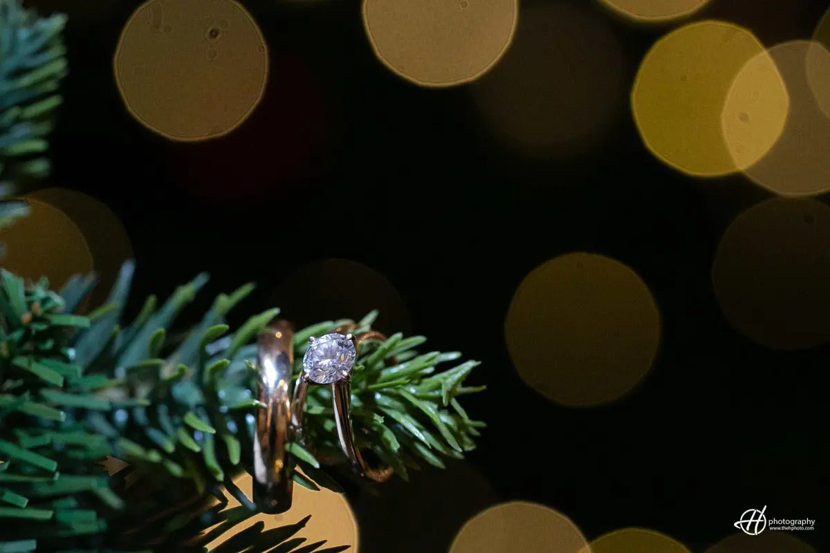 Wedding rings agains Christmas tree lights. wedding rings