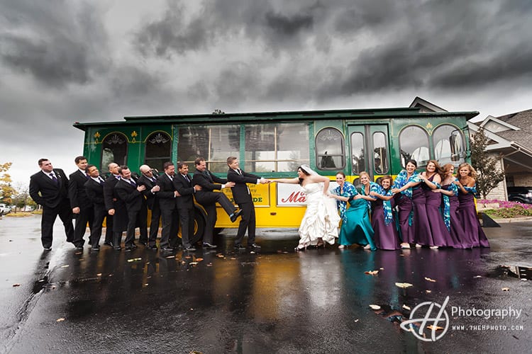 fun wedding photo in front of the wedding trolley