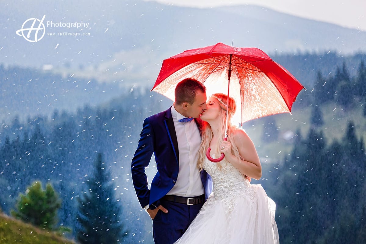 Kissing under red umbrella.