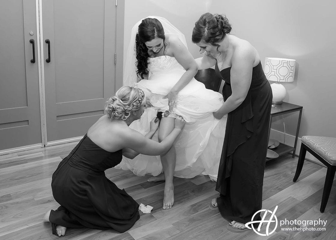 bridemaids helping the bride with the garter