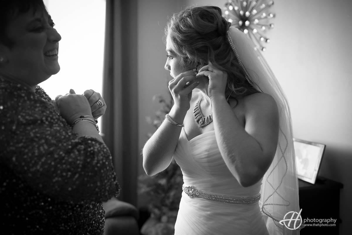 Bride putting the ear rings.