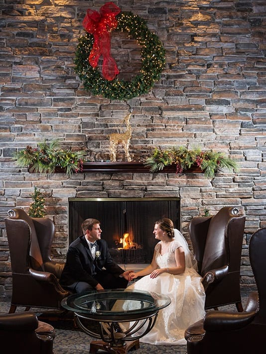 bride and groom by fireplace