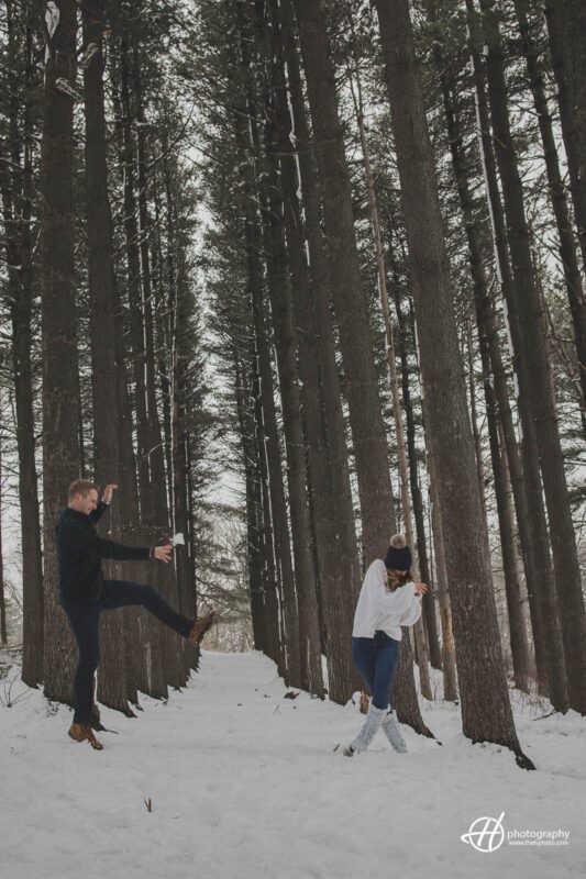 Image of the couple playfully engaged in a snow fight, throwing snowballs at each other in a winter wonderland.