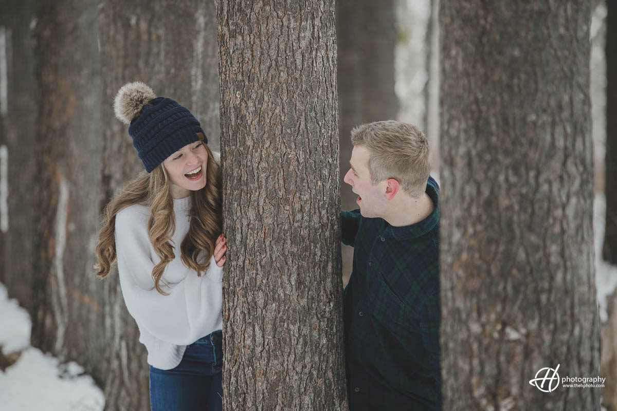 Image of Julia and Joseph having fun playing hide and seek during their engagement session, capturing a playful and joyful moment between the couple